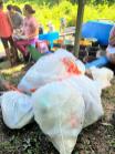 Photo of white trash bags filled with bottles, cans and other garbage.
